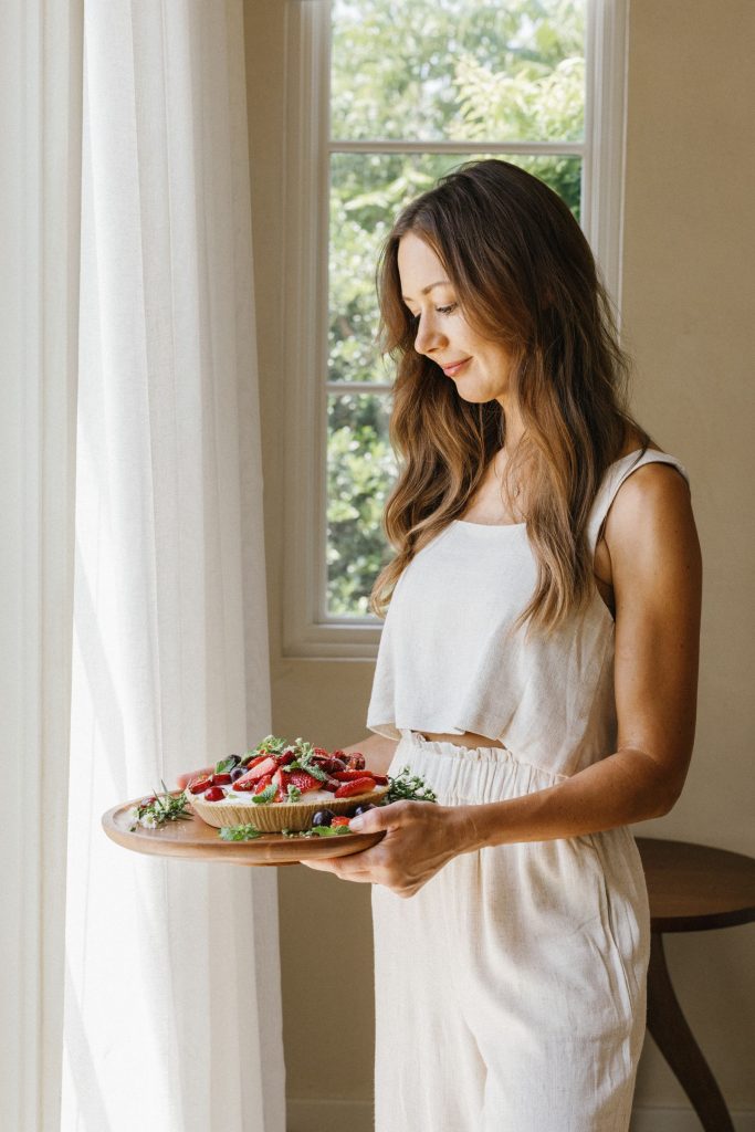 camille styles standing holding cherry berry ice cream pie