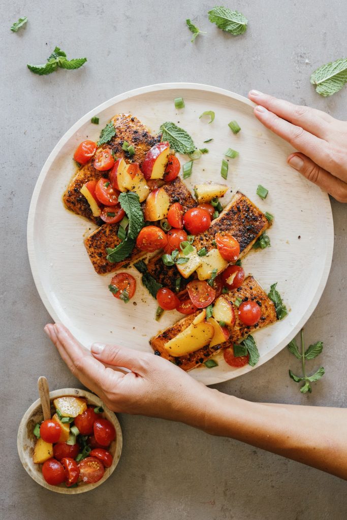 grilled salmon with peach salsa on a white plate