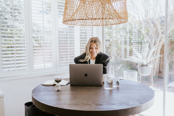 A blonde woman working on laptop.