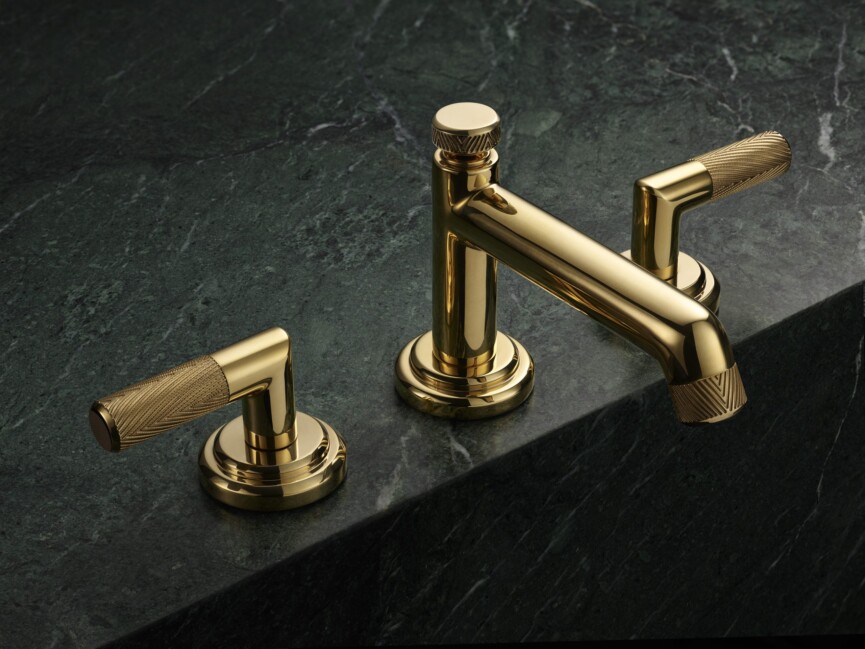 unlacquered brass sink with dark marble countertop