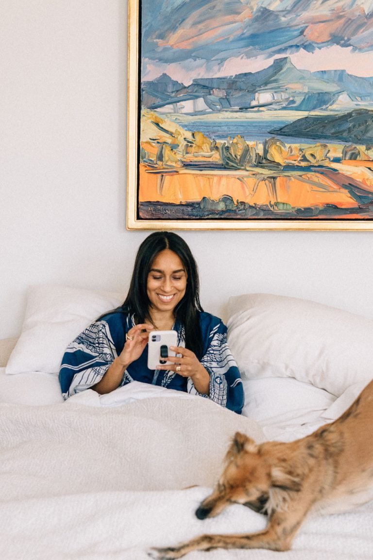 Woman using phone in bed.