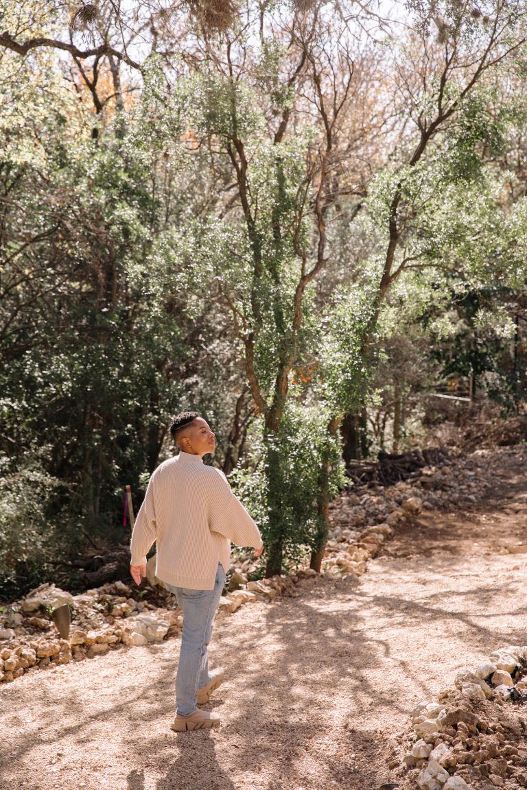 Woman walking in woods outside.