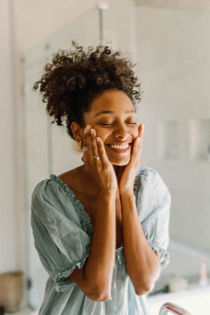 A woman washing her face in the bathroom.