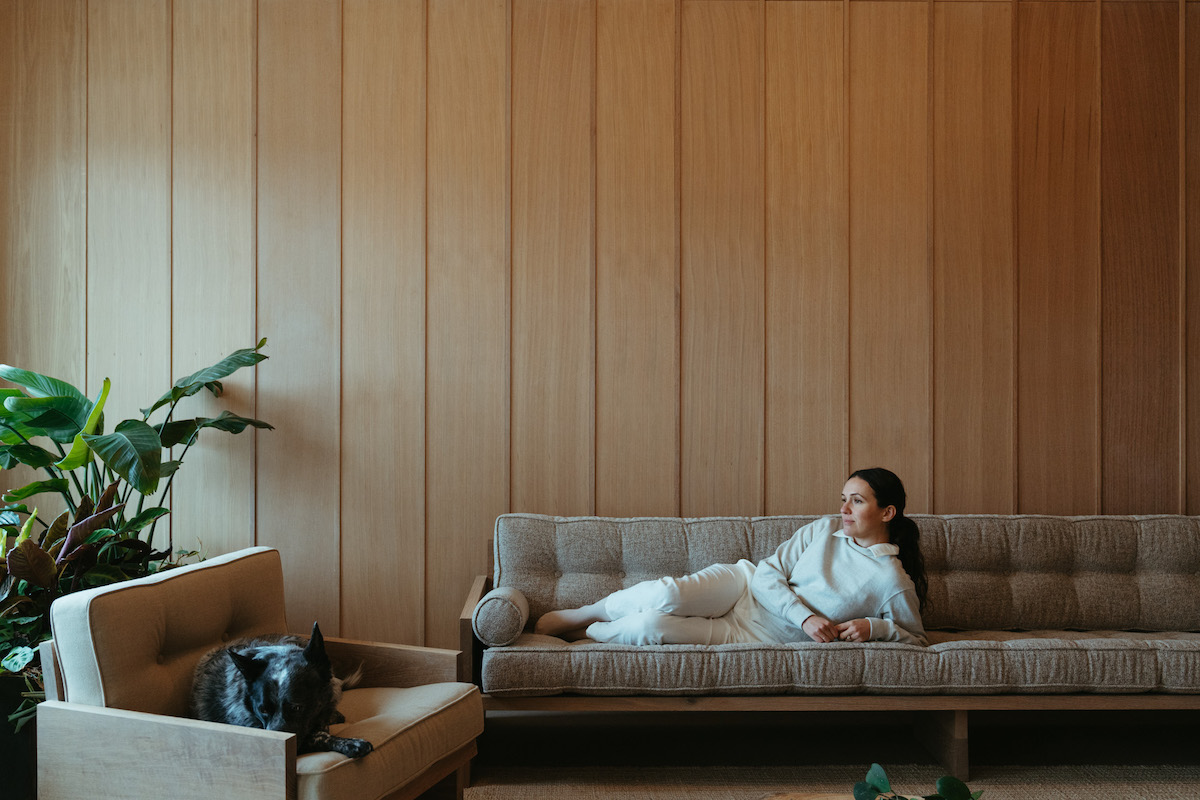 Adriene Mishler sitting on couch with dog.