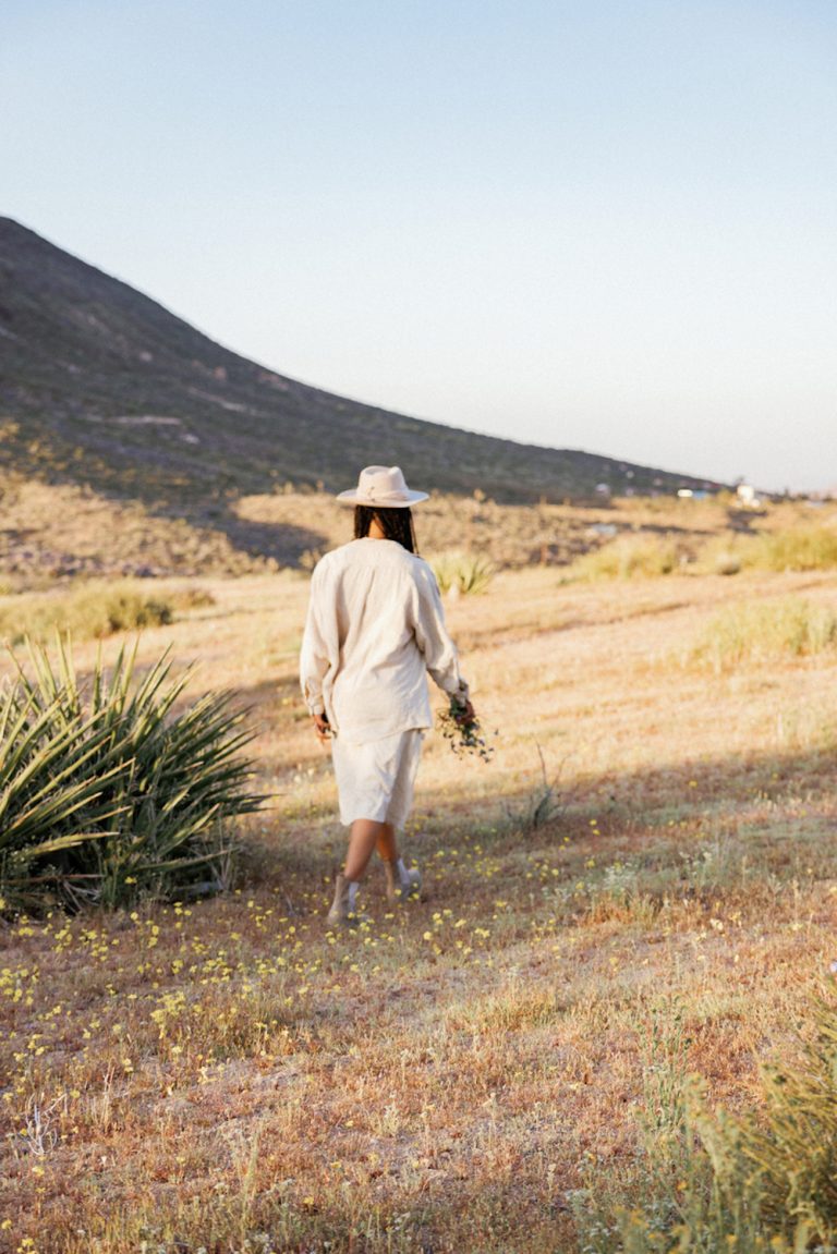 Woman wearing sunhat walking outside in Joshua Tree.