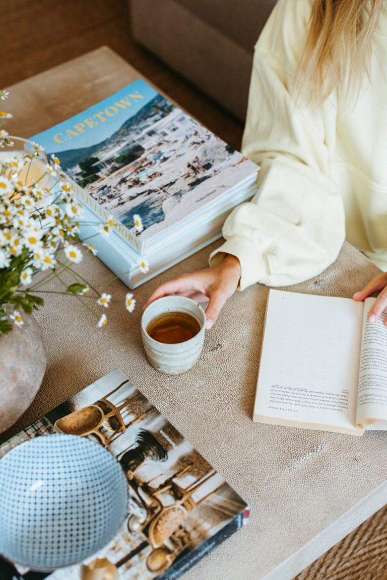 Coffee mug and books on coffee table in living room.