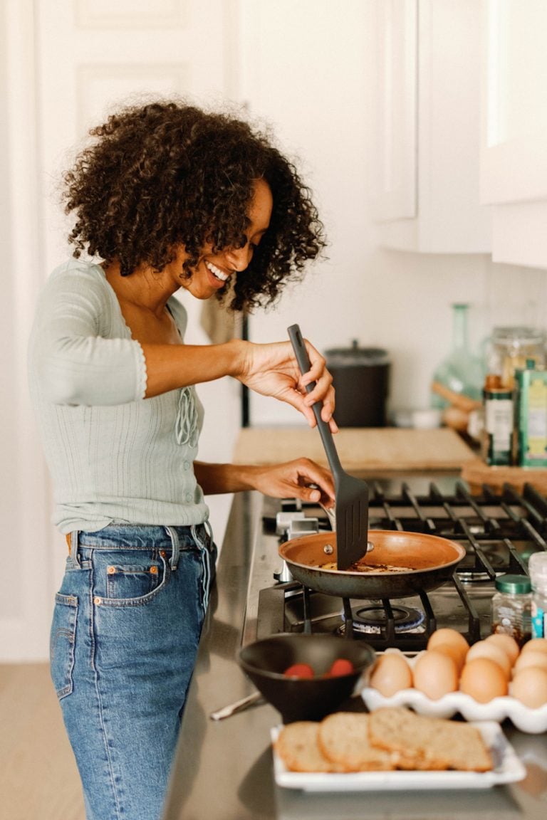 Woman cooking at stovetop.