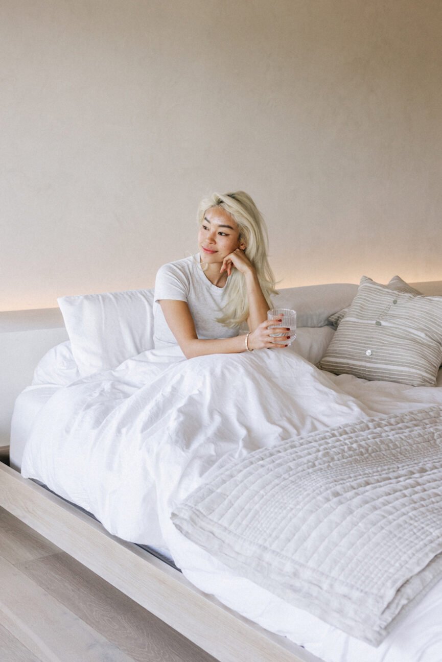 Woman drinking water in bed.