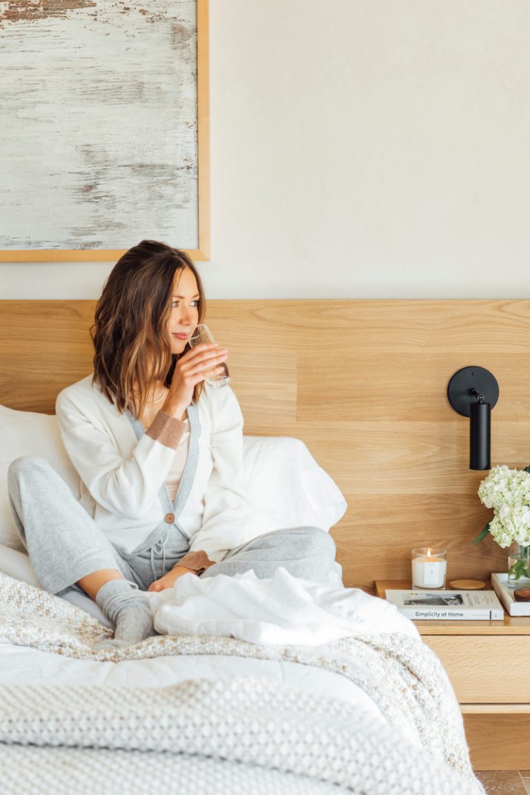 Woman drinking glass of water in bed.