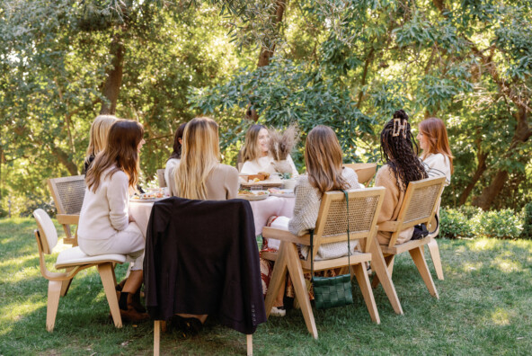 Women gathered at outdoor dining table.