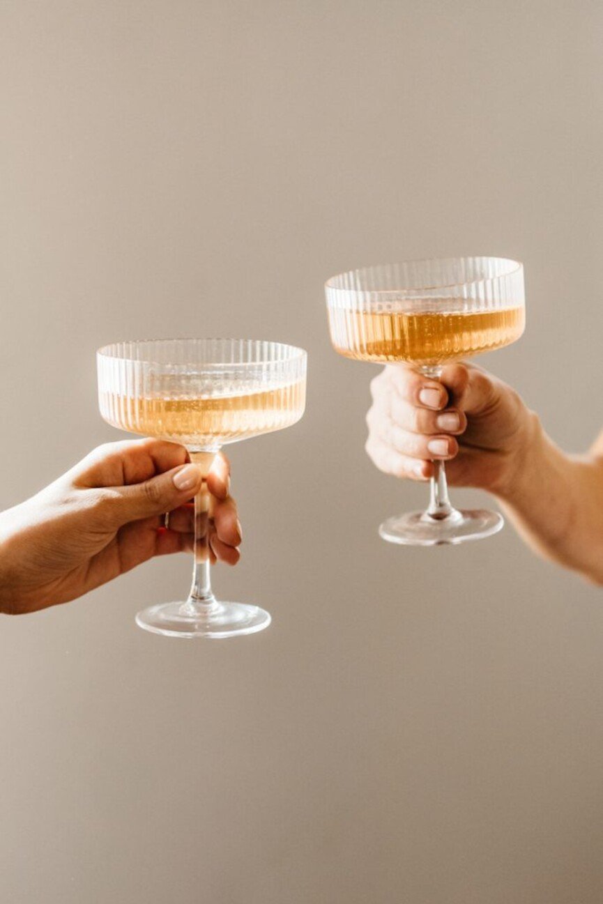 Champagne cheers in coupe glass.