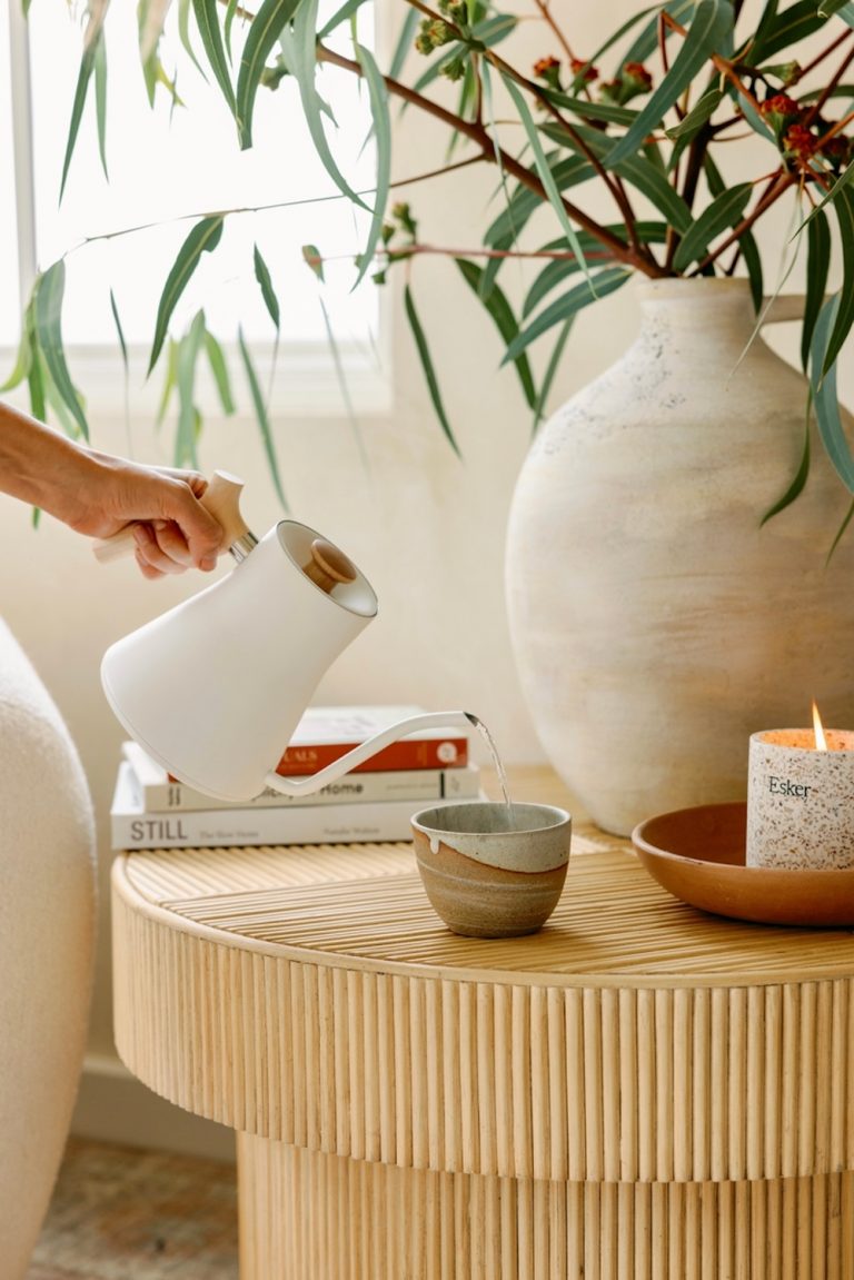 Woman pouring tea into cup.