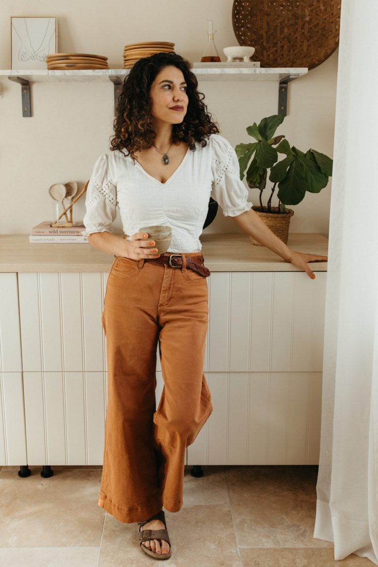 Woman drinking tea in kitchen.