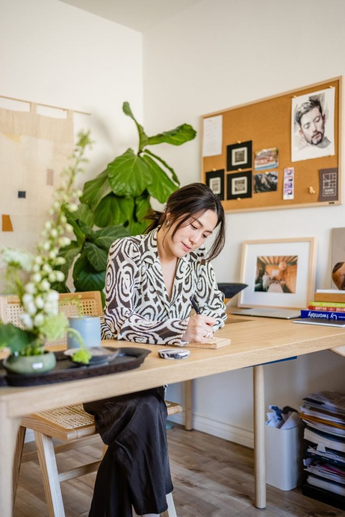 Woman writing at desk.