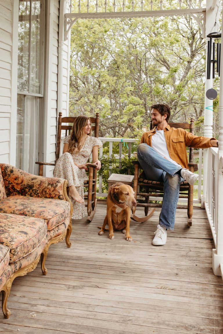 Man and woman sitting on porch with dog.