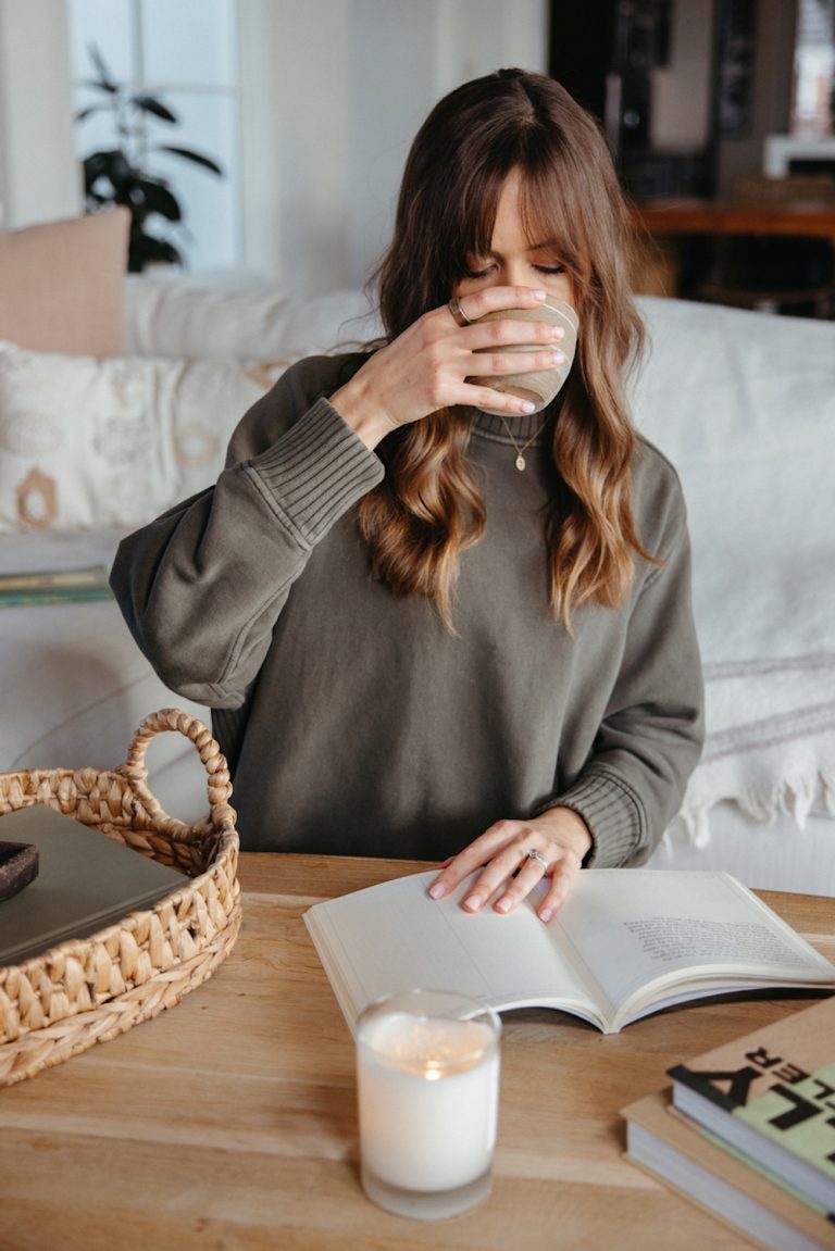 Camille Styles reading and drinking tea.