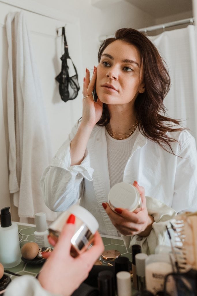 Woman applying face cream.