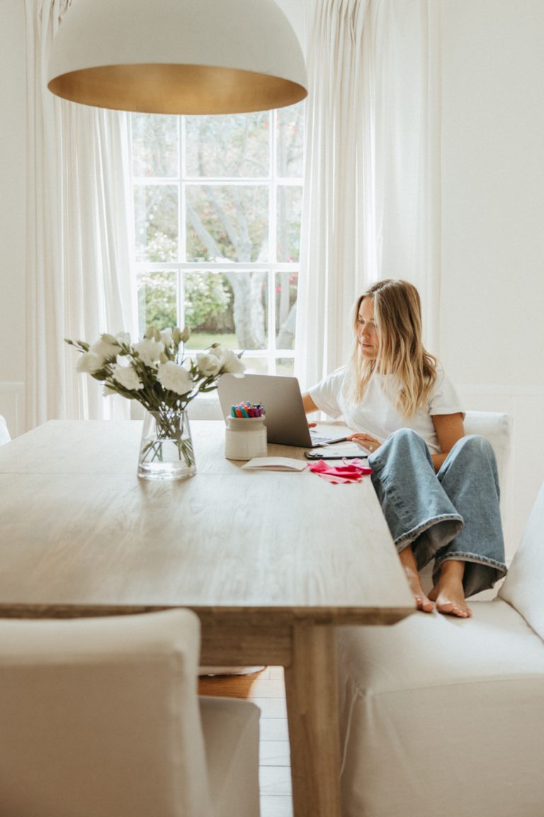 Woman working at table on laptop.