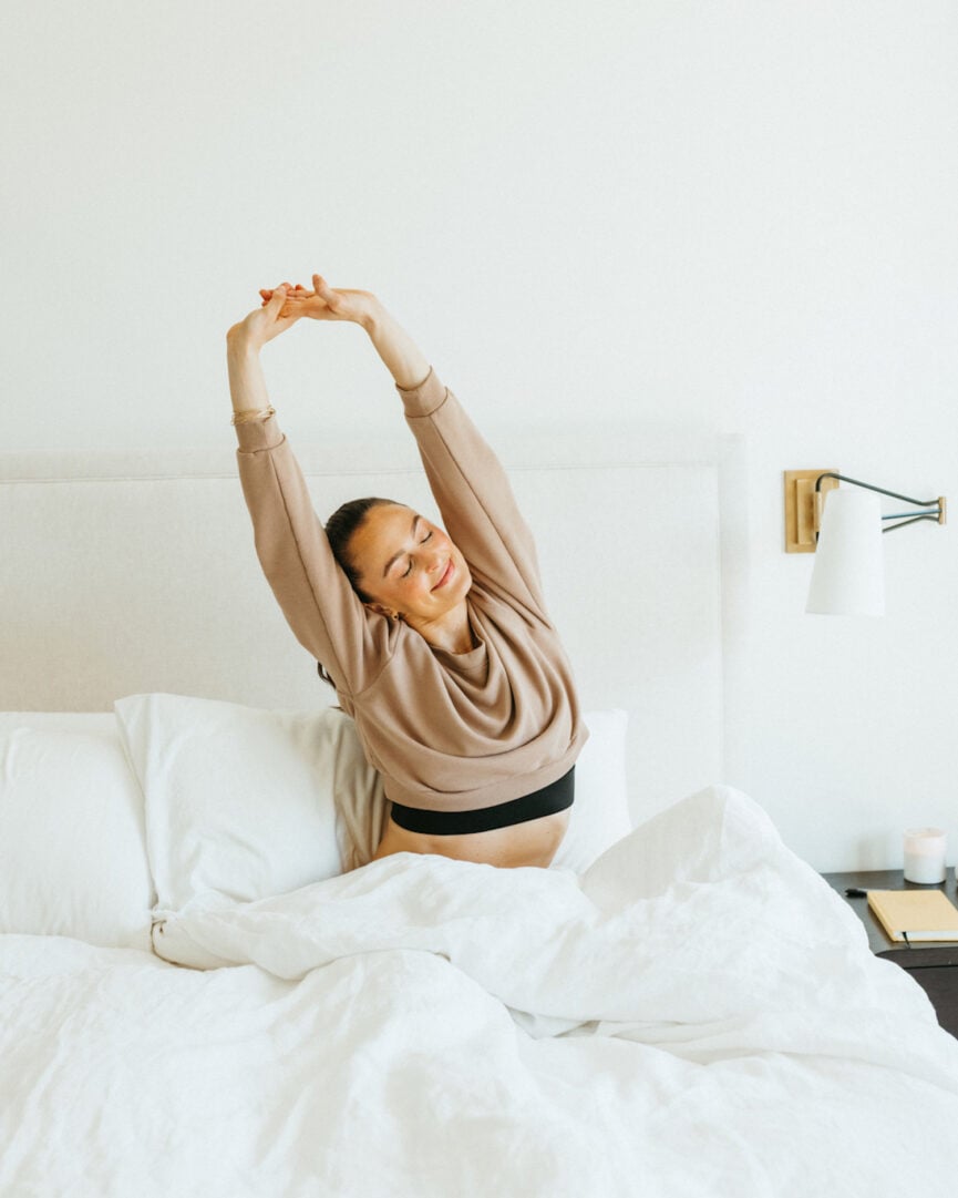 Woman stretching in bed.