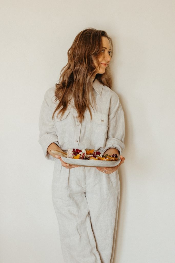 Camille holding roasted honeynut squash recipe with raddichio, goat cheese and pecans