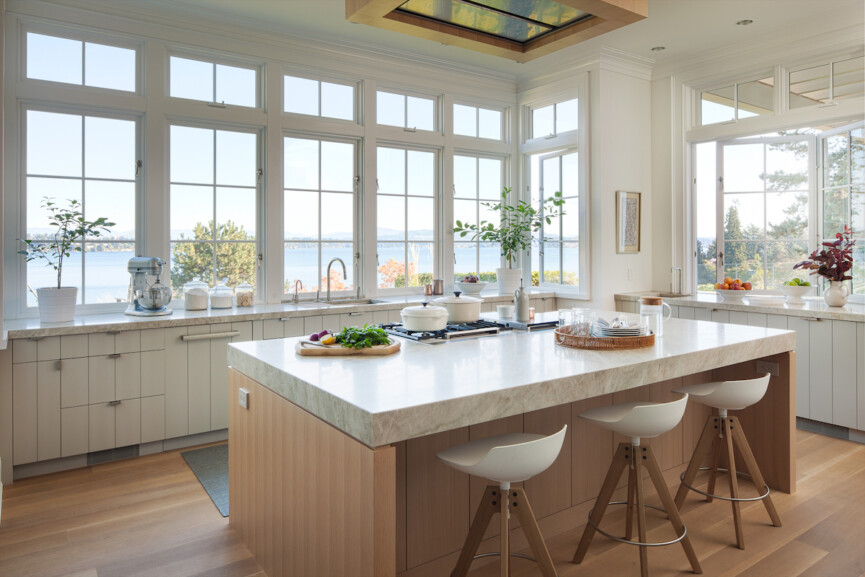 White kitchen with large windows.