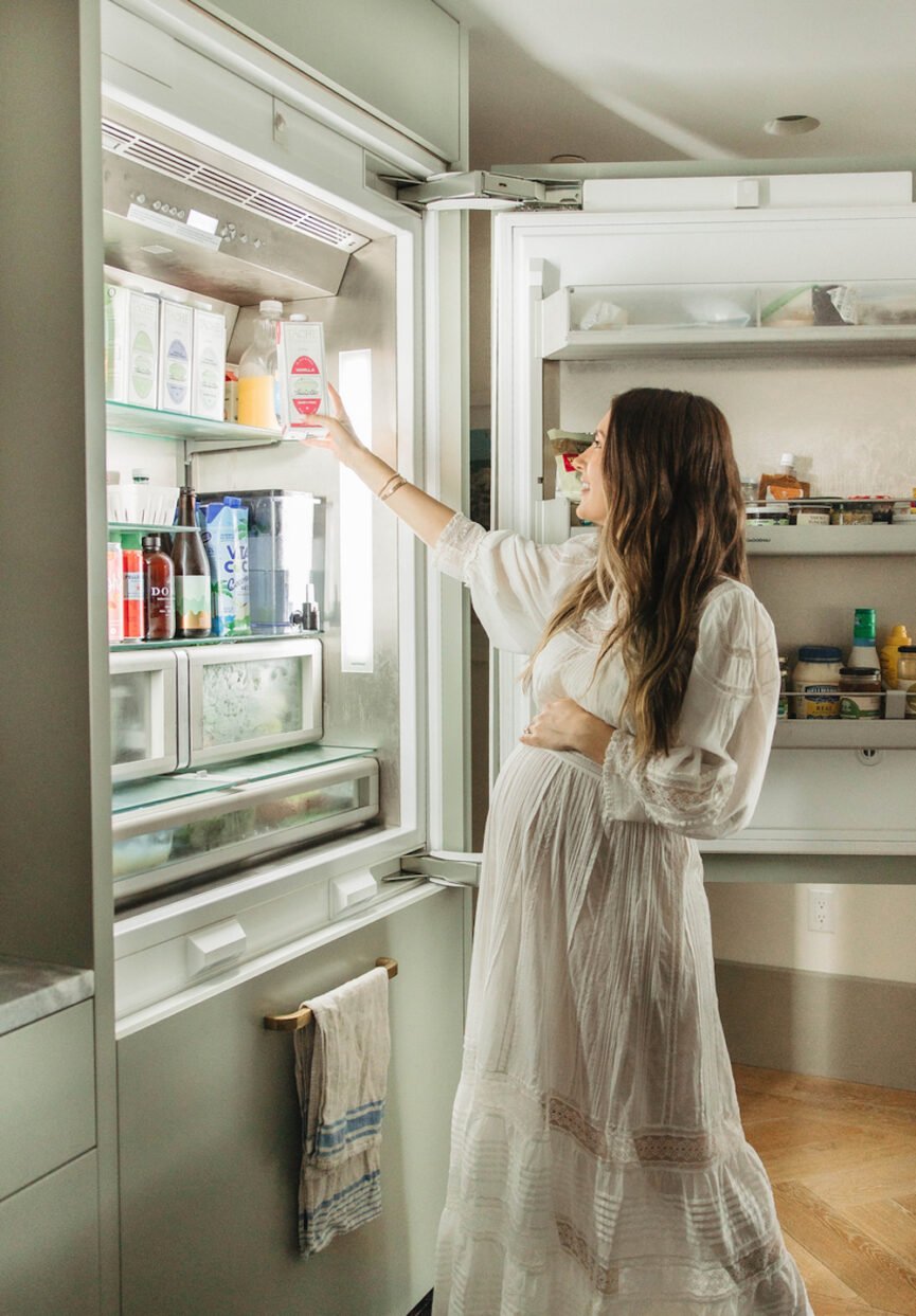 Woman reaching into refrigerator.
