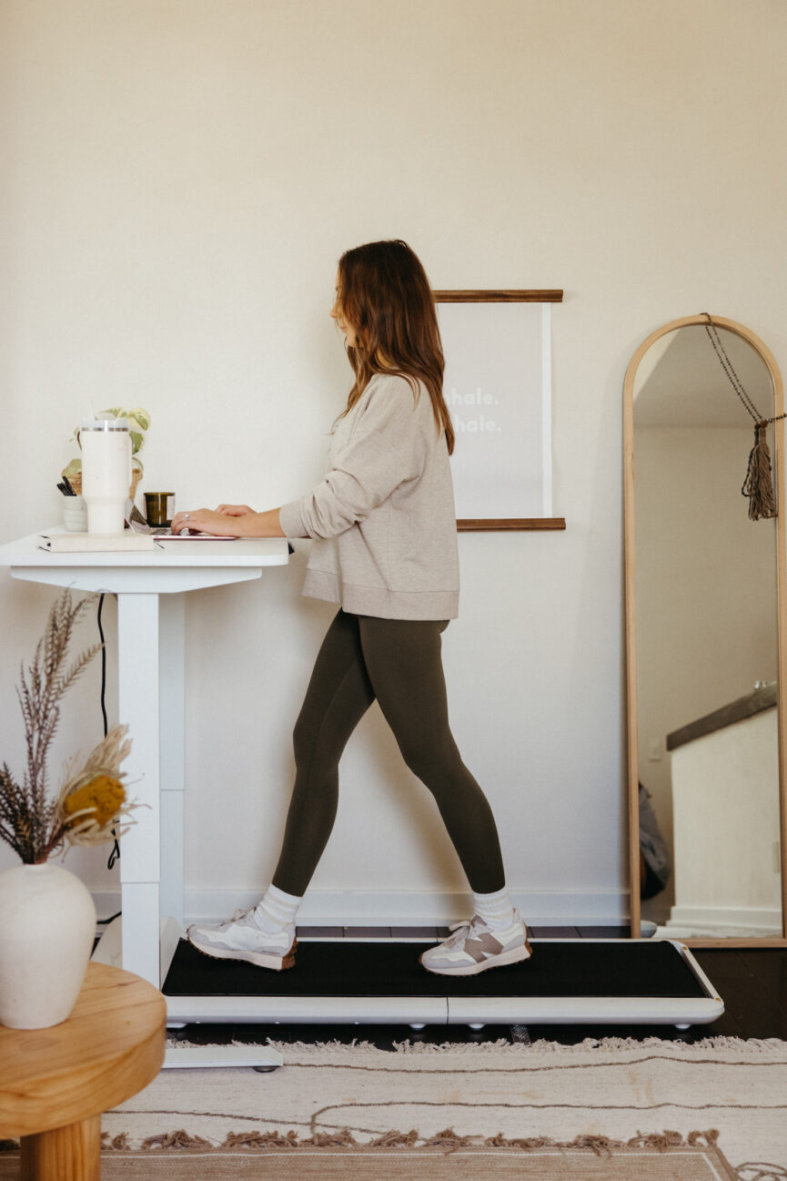 Woman walking on desk treadmill.