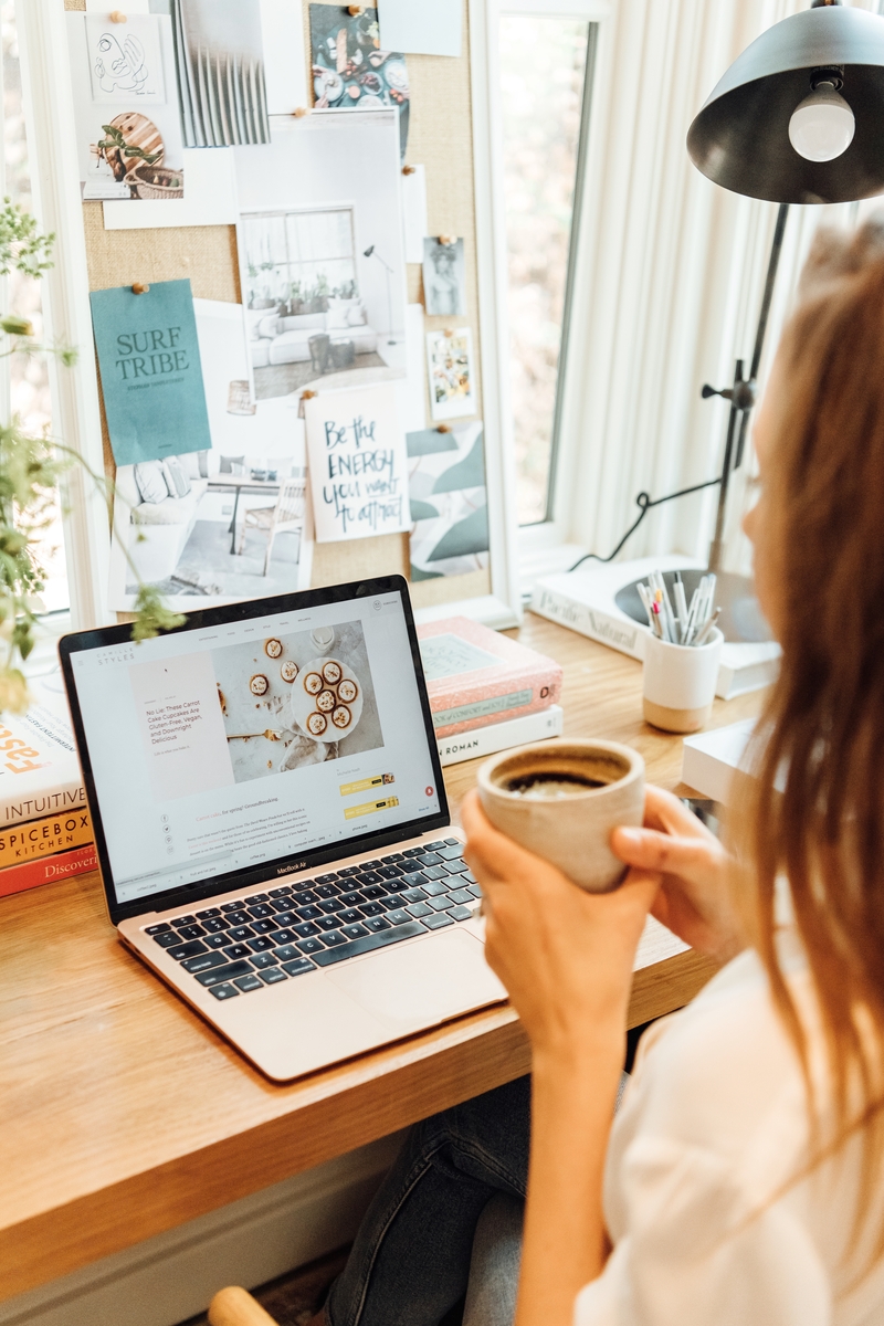 woman organizing photos on the computer with cup of coffee