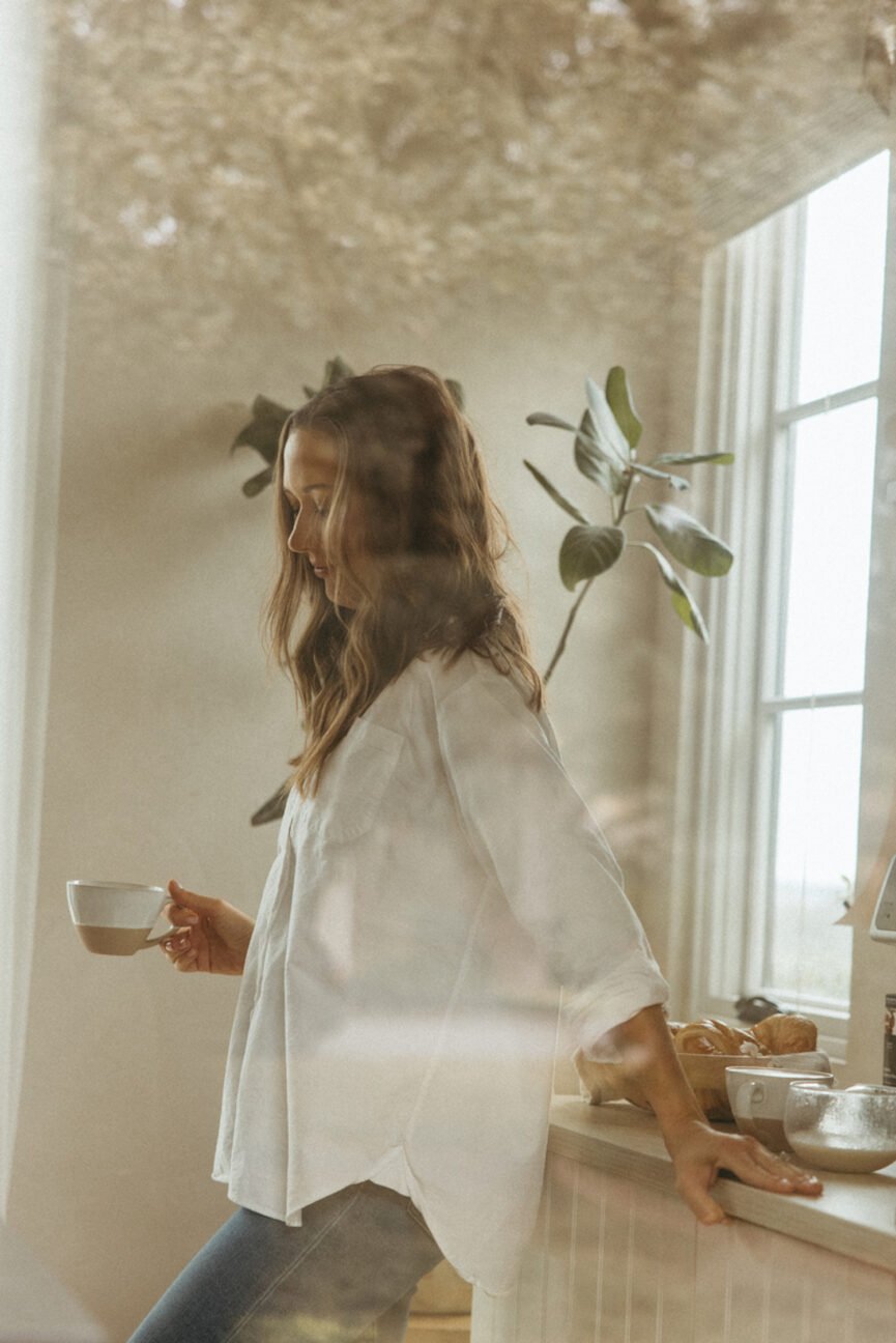 Camille Styles drinking coffee in kitchen.