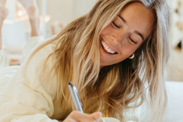 Woman journaling gut health oral hygiene.