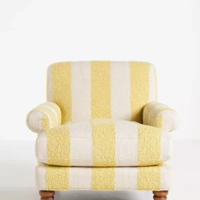 An overstuffed accent chair with three butter yellow stripes down the front of it from Anthropologie