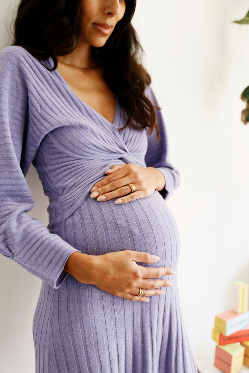 Pregnant woman wearing purple dress.