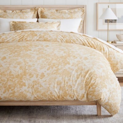 A bed with a Sorrel Toile Duvet Cover from Pottery Barn in Harvest Gold