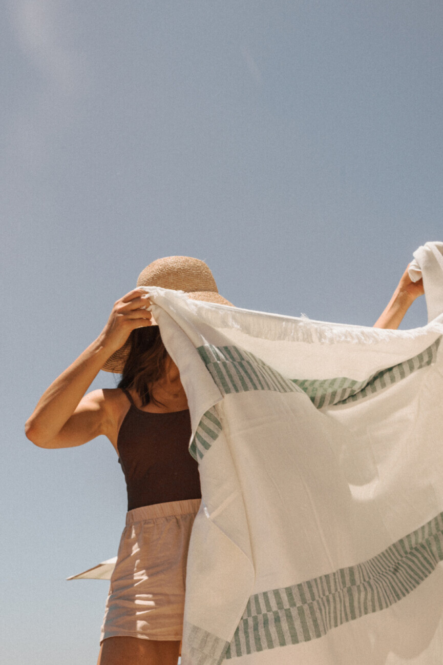 Woman shaking beach towel.