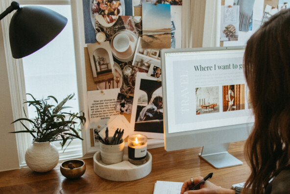 Woman writing list at desk.