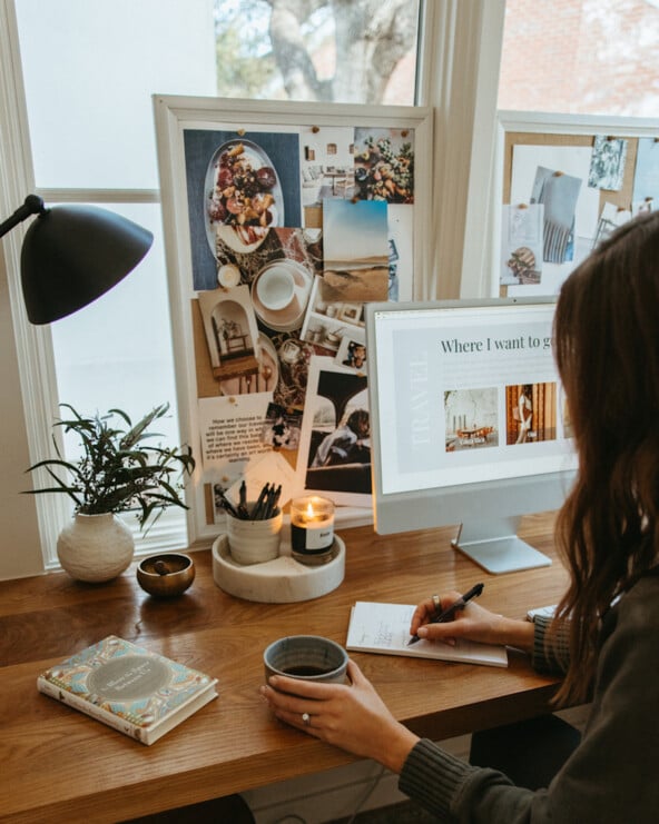 Woman writing list at desk.