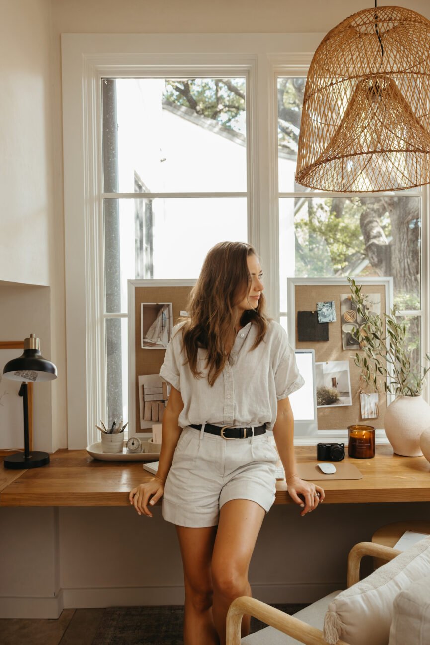 Camille Styles sits on the table.