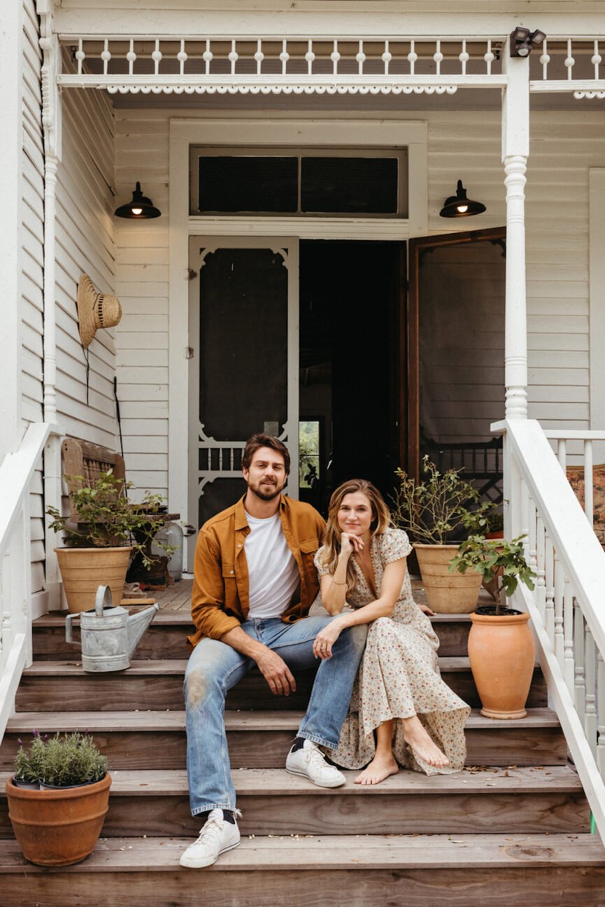 Husband and wife couple sitting on outdoor porch steps