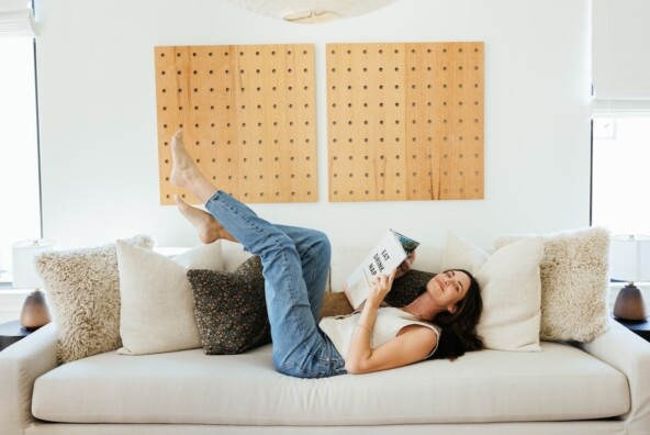 Odette Annable reading on couch.