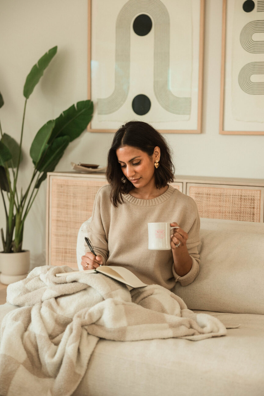 Mulher escrevendo um diário e tomando café.