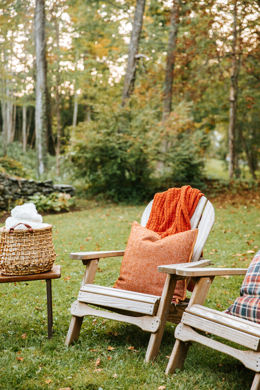 There are Adirondack chairs and cozy blankets outside.