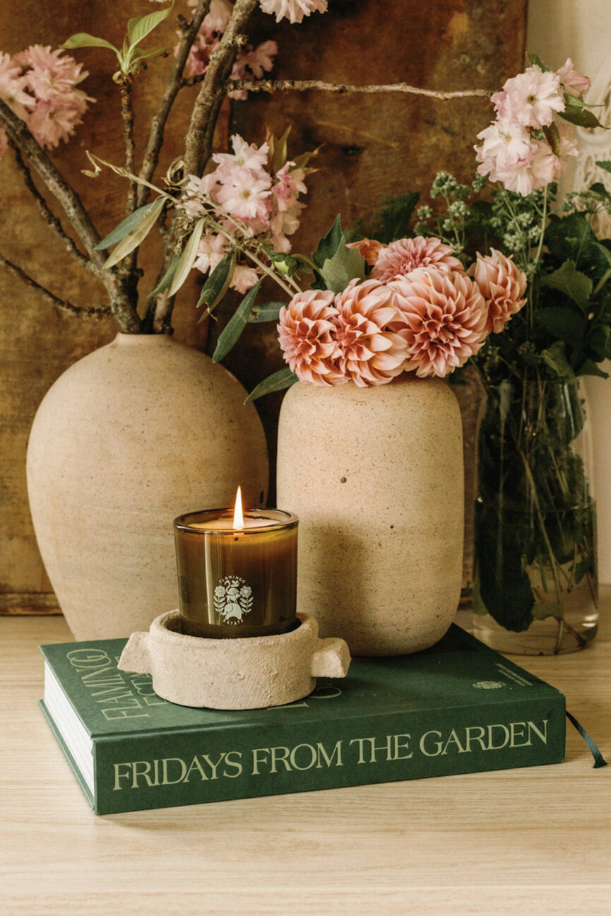 Velas, vasos de flores e livro de mesa de centro.