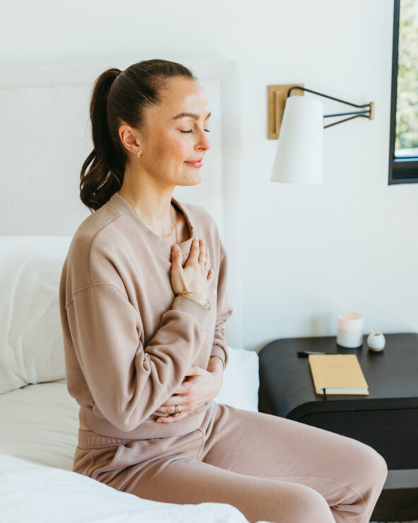 Megan Roup meditating on bed.