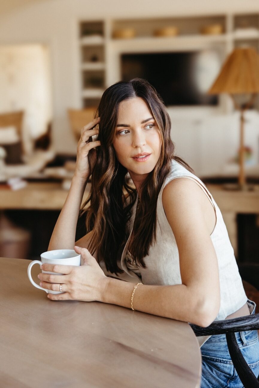 Mulher tomando café na mesa.