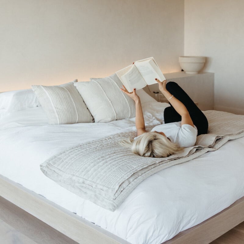 Remy Ishizuka reads a book in bed