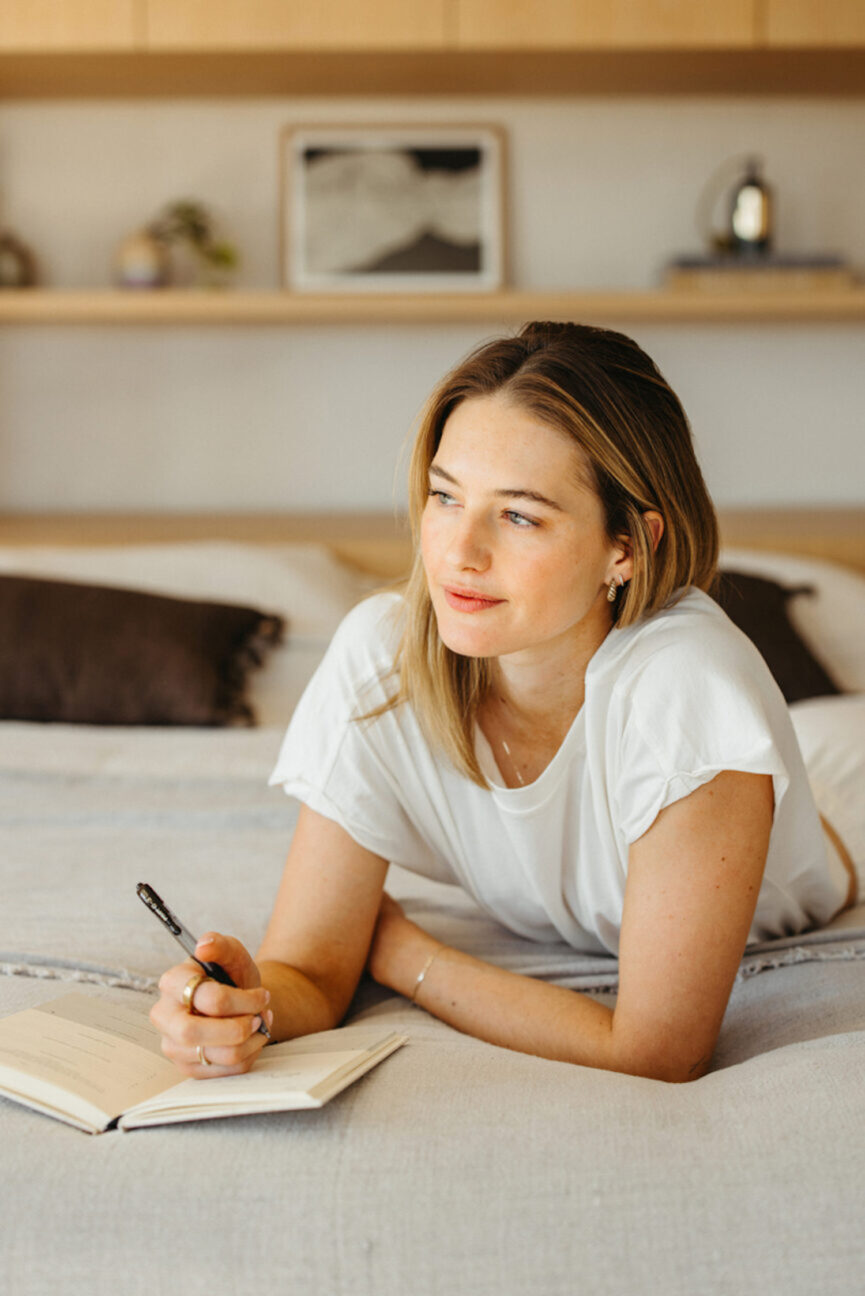 Sanne Vloet escribiendo un diario en la cama.