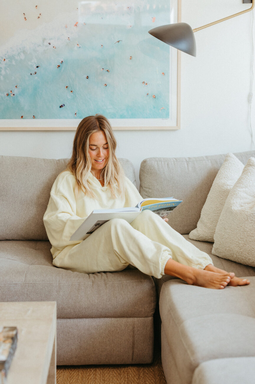 woman reading book on sofa