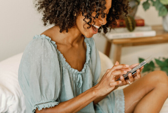 Woman using phone in bed.