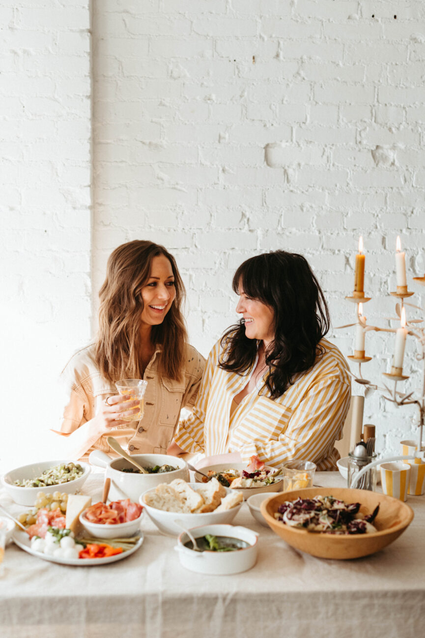 Women smile at the dinner table.