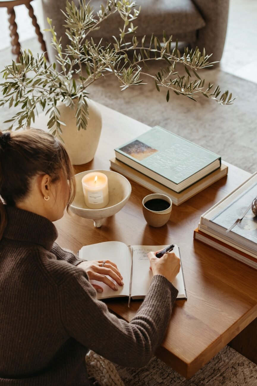Woman journaling using the best fall candles